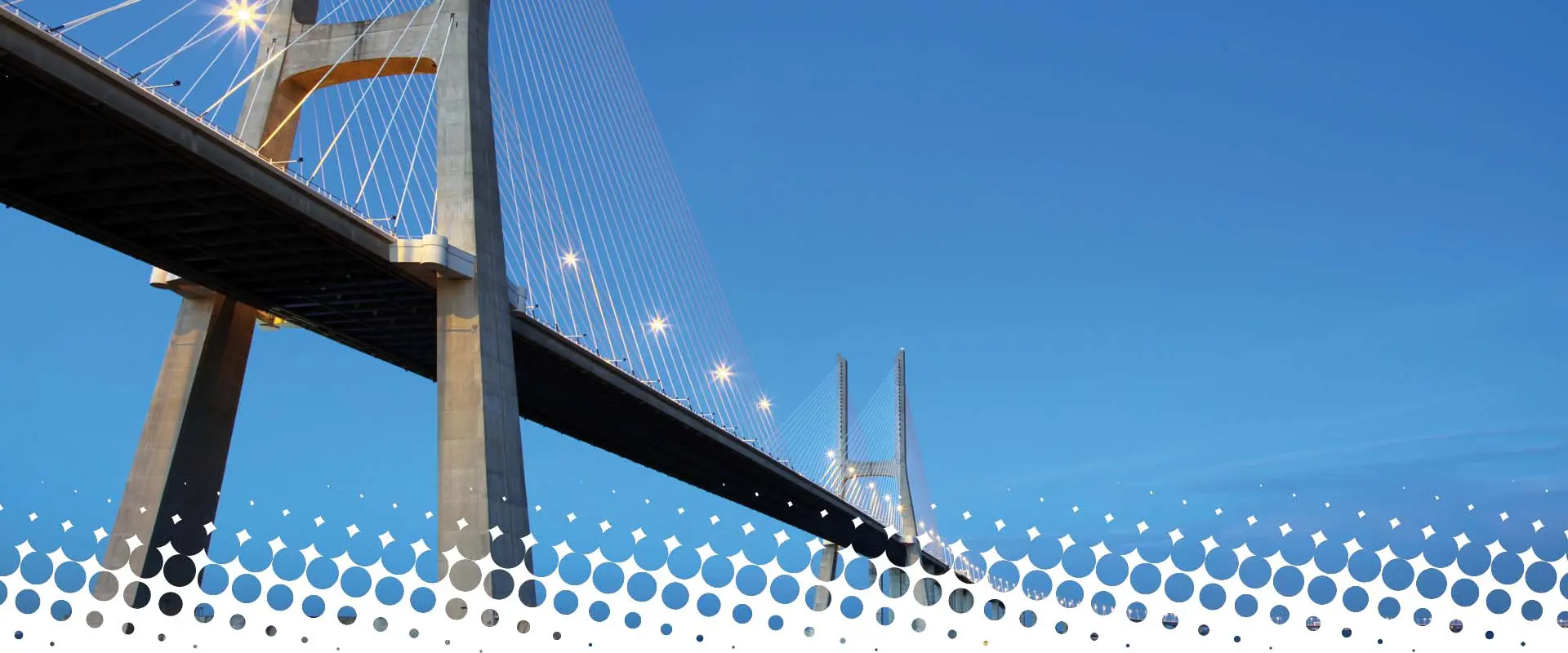 Large modern cable-stayed bridge against a blue sky.